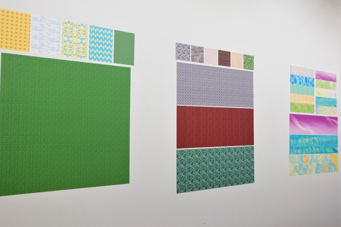 様々なデザインのUVプリントしたオリジナル壁紙の試作品を壁に貼り付けて色味を確認
