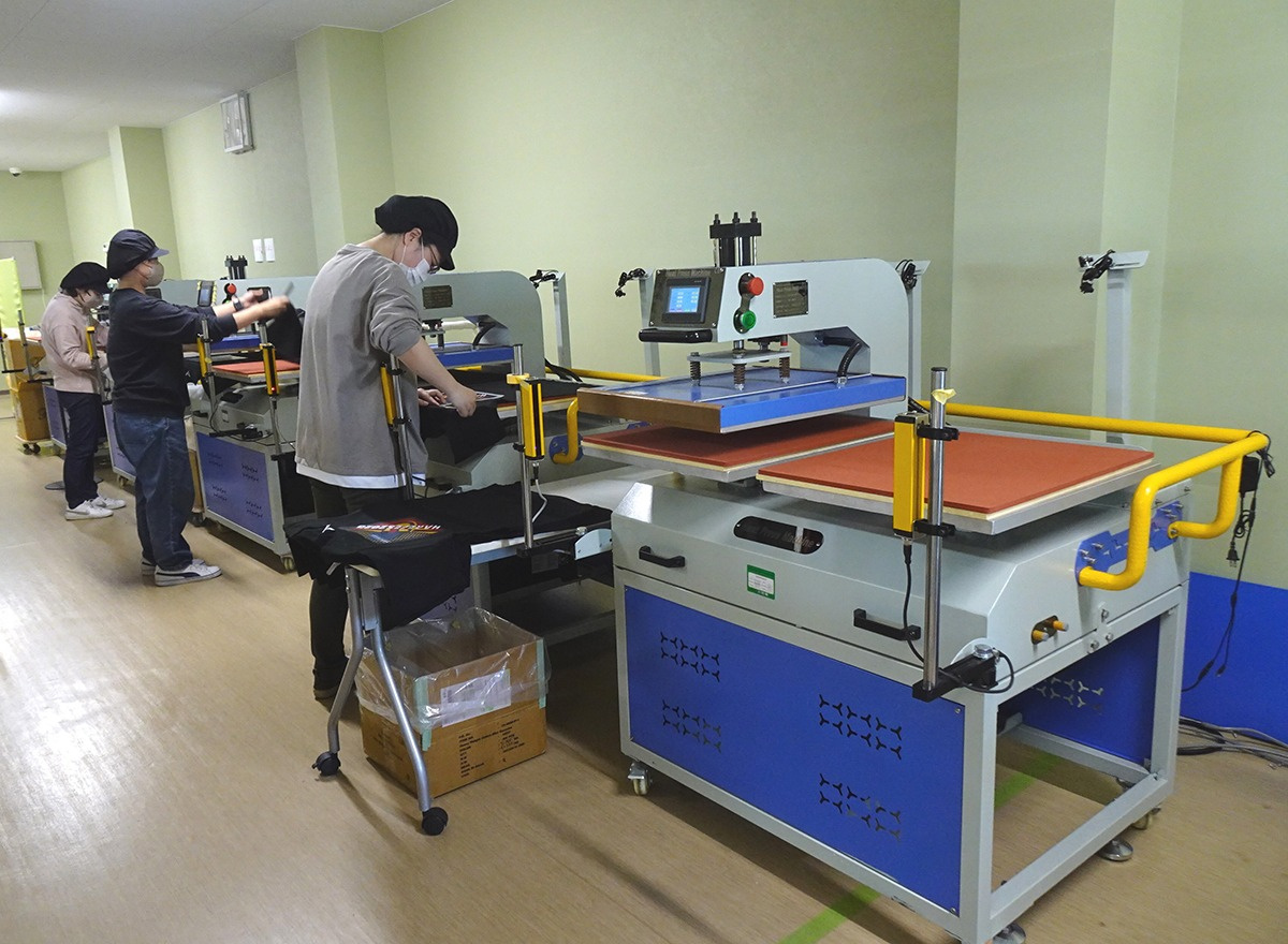 仕切りを挟んだ隣の部屋でプレス作業